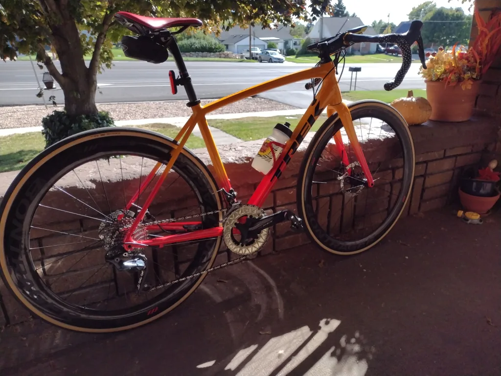 Orange and red road bike with Bontrager tires on a patio