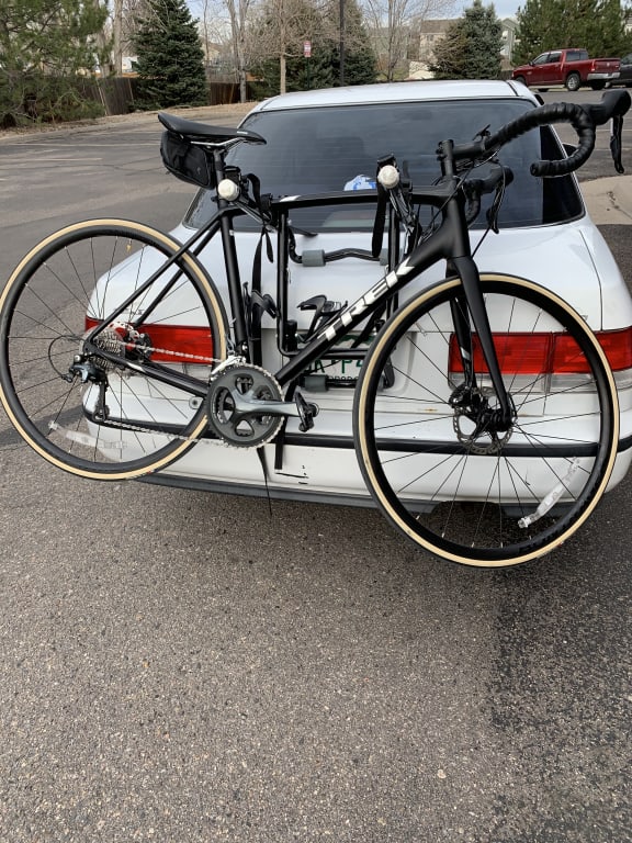 Black road bike with tan-wall Bontrager tires on a car rack